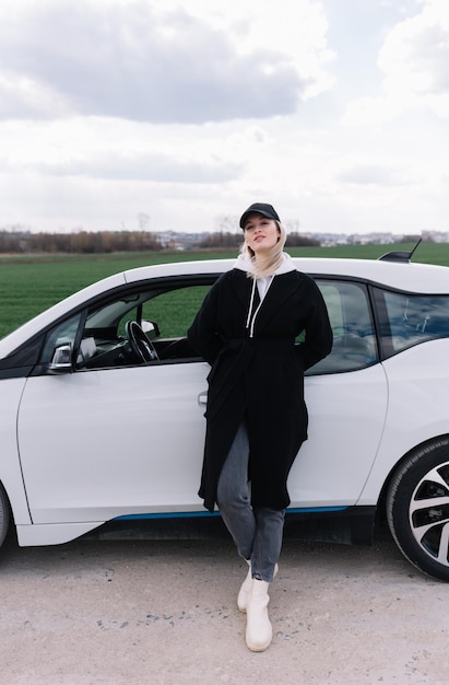 Woman near a rental electric car Vehicle charged at the charging station