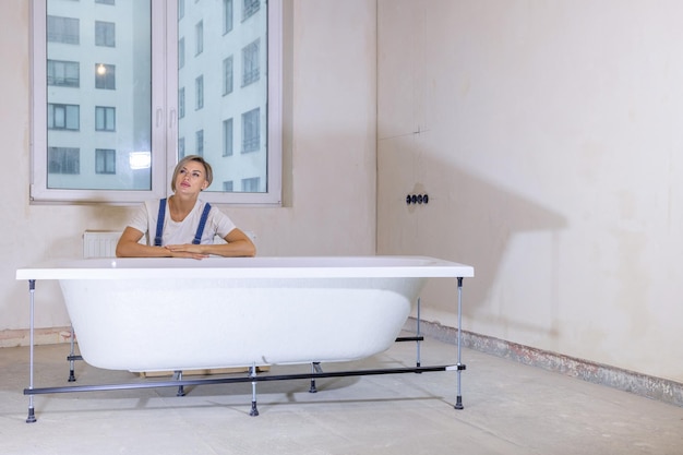 Woman in new apartment with dreams about new life Bath is in middle of room Renovation in new apartment Repair work of home