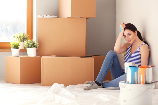 Woman in a new home with cardboard boxes Woman in the house