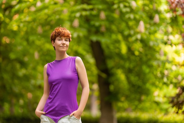 Woman of non binary gender identity in summer park