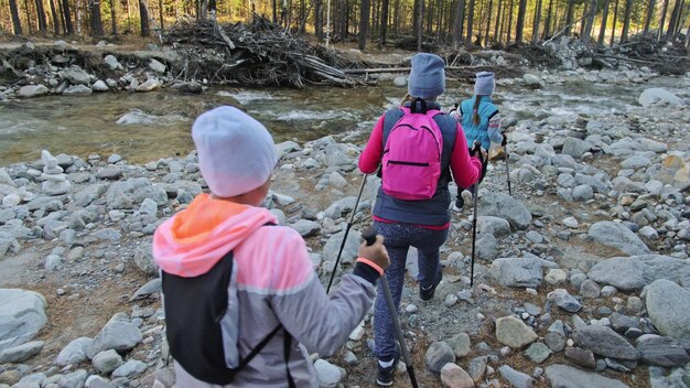 Woman do Nordic walking in nature Girls and children use trekking sticks and nordic poles