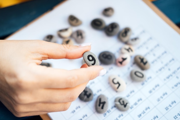 Woman numerologist hand with pebble stone with number six 6