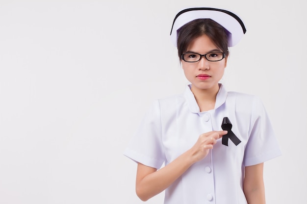 Woman nurse hand holding black ribbon bow, sad unhappy mourning woman, studio white isolated of asian young adult model