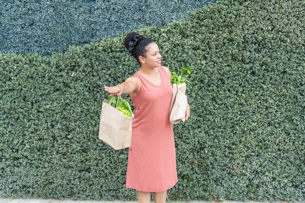 Photo woman offering fresh greens from paper bag