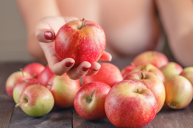 Woman offering red apple, shallow DOF, Focus on the apple