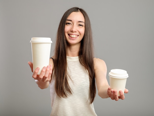 Woman offering white cups of coffee