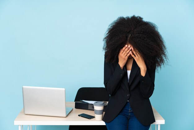 Woman in an office covering her face