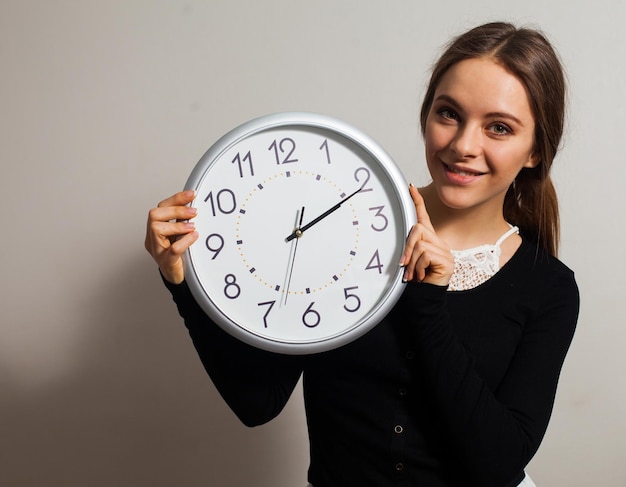 Woman in office with big white clock