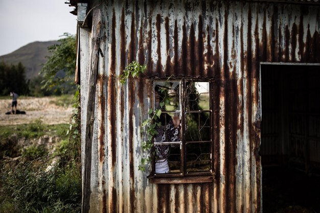 Foto donna in un vecchio capanno nel campo