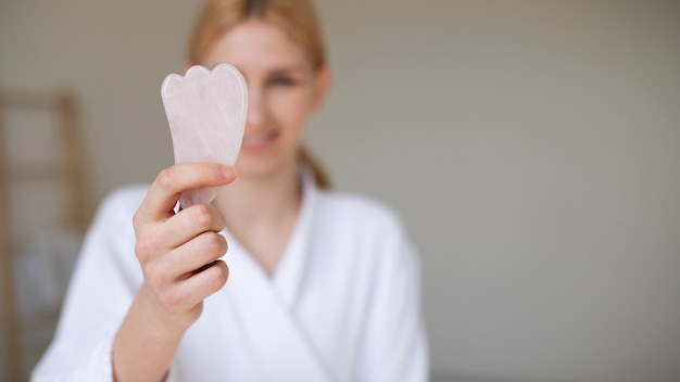 Woman ongoing gua sha face procedure