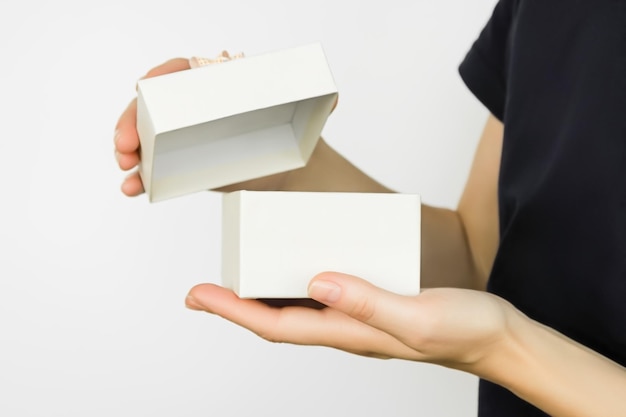 woman opening a cardboard gift box on a white background