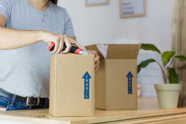 Photo woman opening a package with cutter