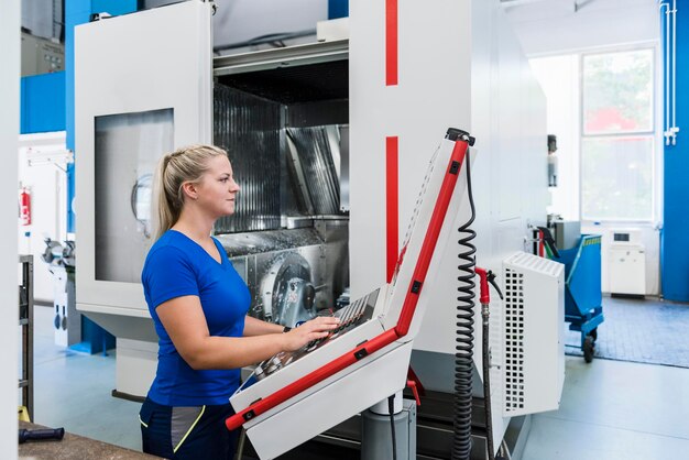 Woman operating control panel in industrial factory