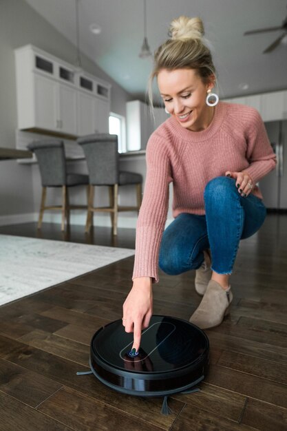 写真 自宅でロボット掃除機を操作する女性