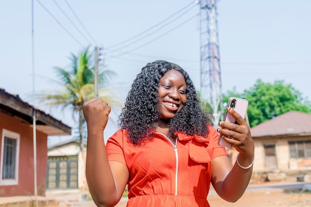 A Woman in an Orange Dress Holding a Cell Phone