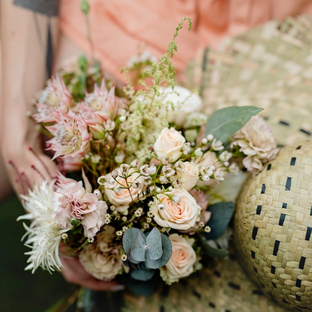 Photo woman in an orange jumpsuit with a bouquet of flowers