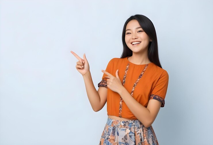 オレンジ色のシャツを着た女性が平和のサインを作っています