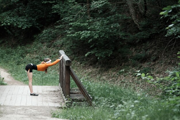 조깅하기 전에 워밍업 오렌지 스포츠 후드에있는 여자