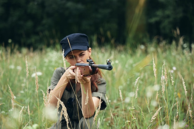 Woman on outdoor In the shelter with weapons in hand the sight of fresh air weapons green