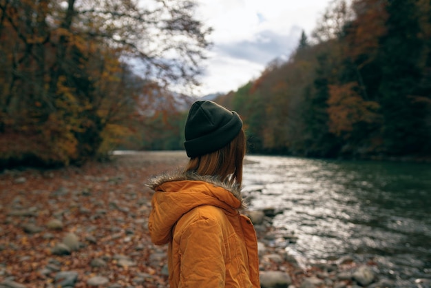 Woman outdoors autumn forest mountains river travel High quality photo