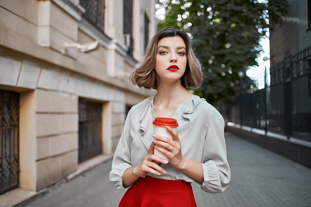 屋外での女性コーヒーカップ散歩レジャー夏高品質の写真