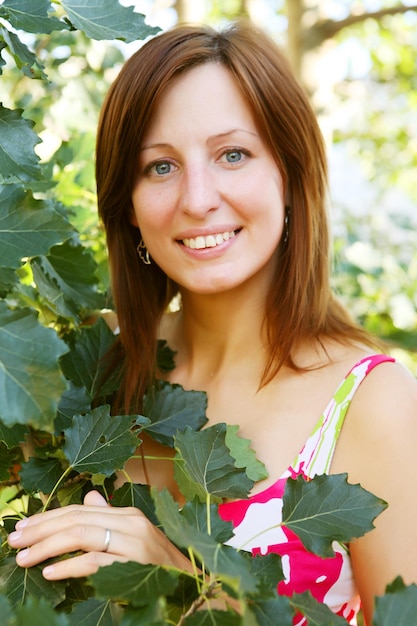 Woman outdoors under green leaves