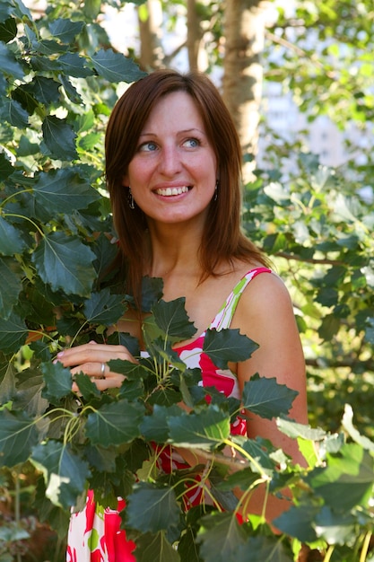 Woman outdoors under green leaves