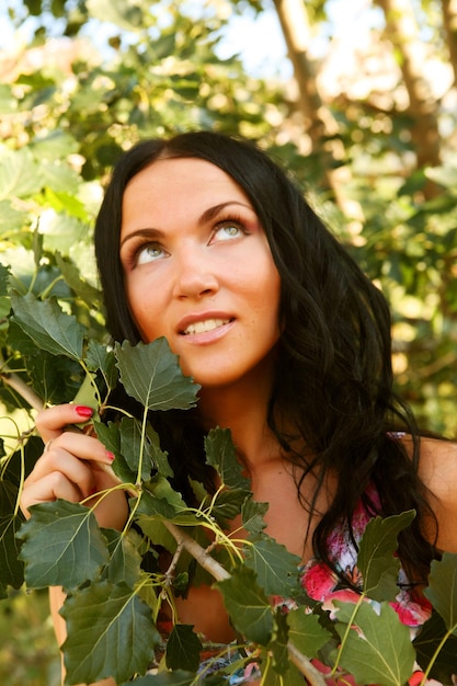 Woman outdoors under green leaves