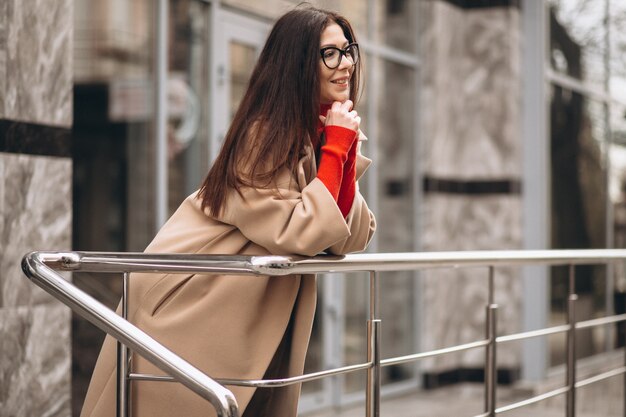 Woman outside by the business centre in beige coat