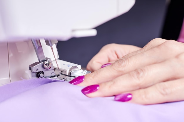 Photo woman overstitches a dress on an overlocker