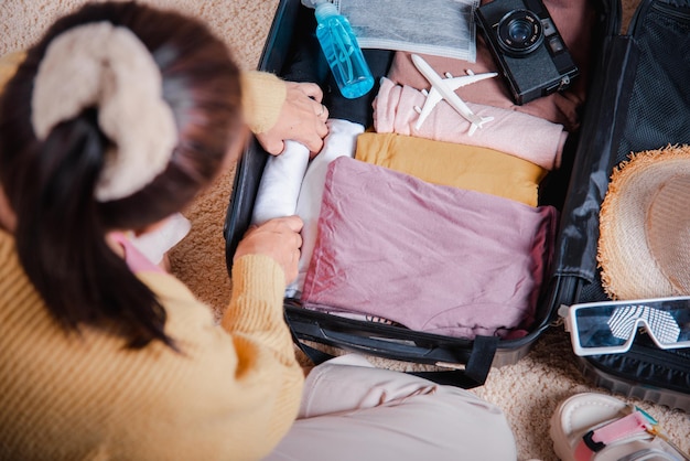 Woman packing clothes in luggage for new journey