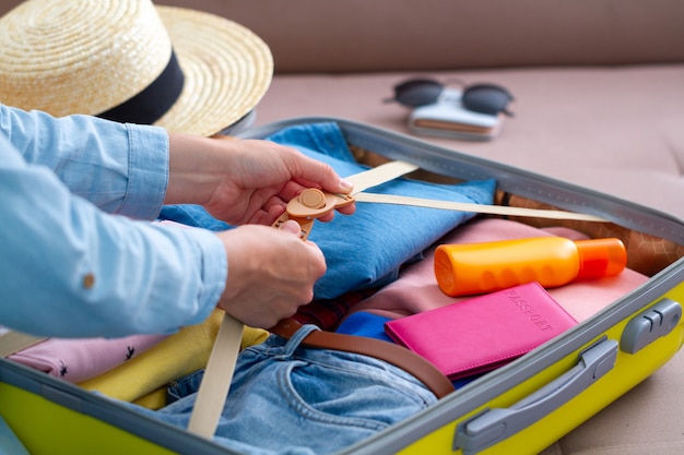 Woman packing a luggage at home for a new journey and traveling. Traveling suitcase for holiday travel and vacation