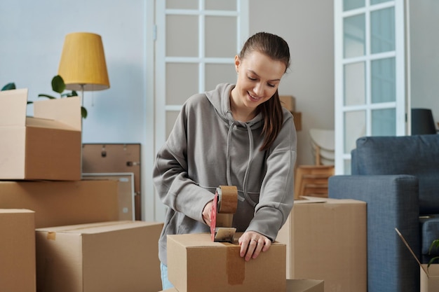 Woman packing things in cardboard boxes