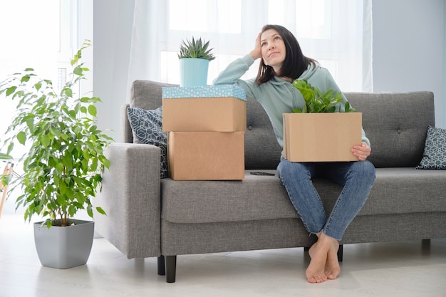 Woman packing or unpacking moving home. Moving a young couple