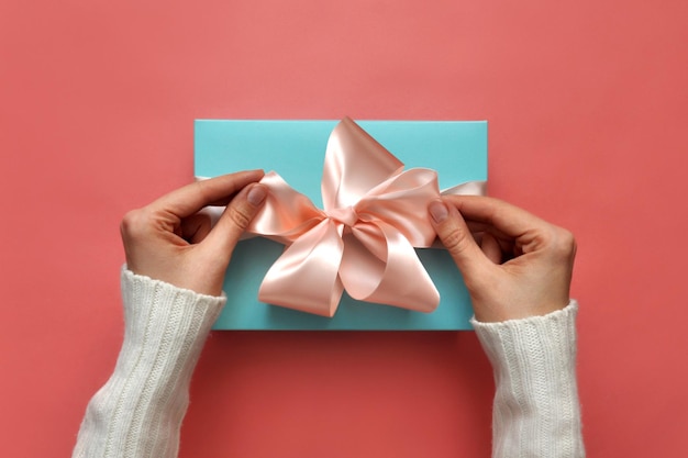 A woman packs a holiday gift in a blue box