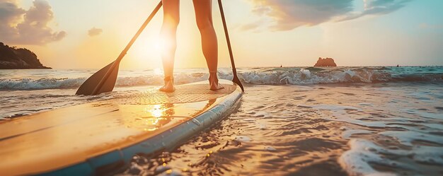 Photo a woman paddles her surfboard on the beach at sunset