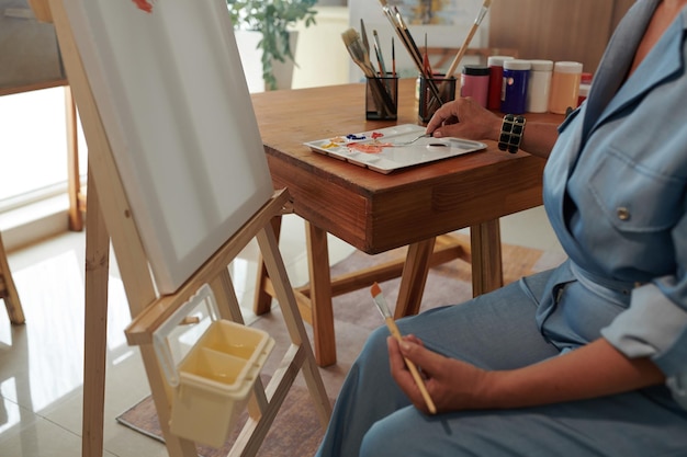 Photo woman painting picture on easel