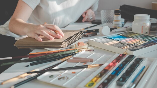 Woman painting a picture with a brush. Learning to draw at home.