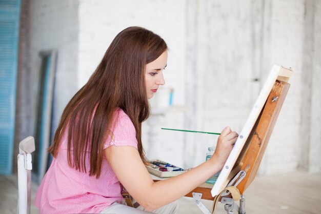 Woman paints picture on canvas