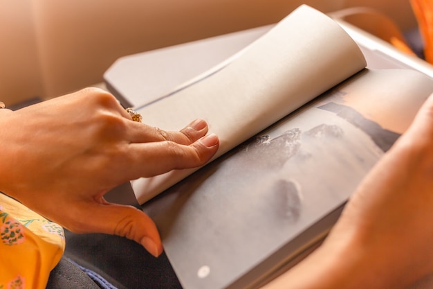 Woman passenger killing time by reading book while traveling on the plane.