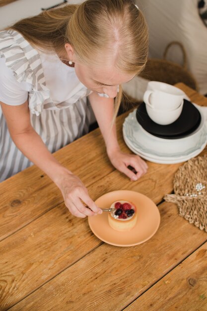 女性のパティシエがデザートを飾ります。製菓または料理コースのコンセプト