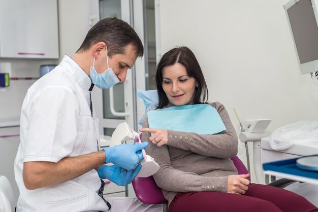 Woman patient talking with dentist about mouth hygiene