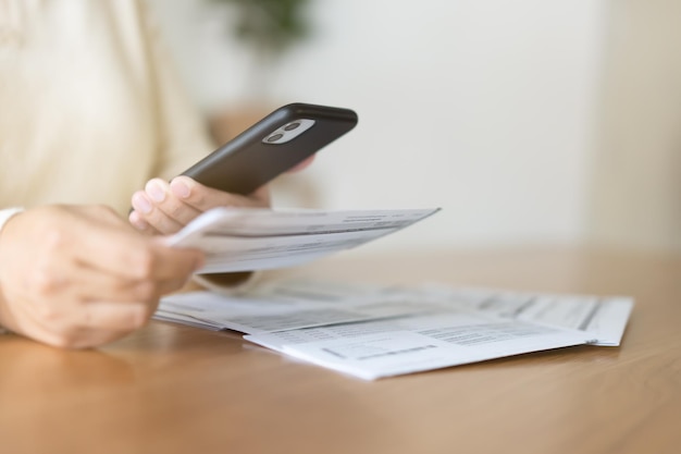 Foto donna che paga le bollette tramite telefono cellulare concetto di pagamento senza contanti