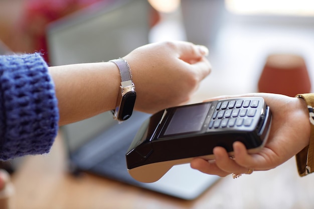 woman paying contactless with smart watch at shop