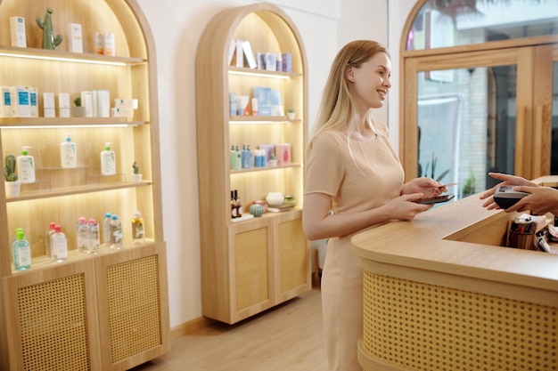 Photo woman paying in spa salon