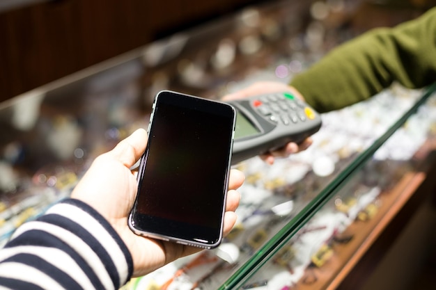 Photo woman paying with nfc technology