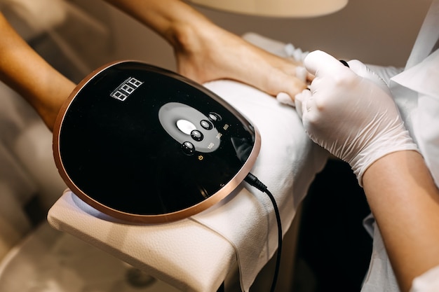 Woman at a pedicure procedure, using shellac uv led lamp