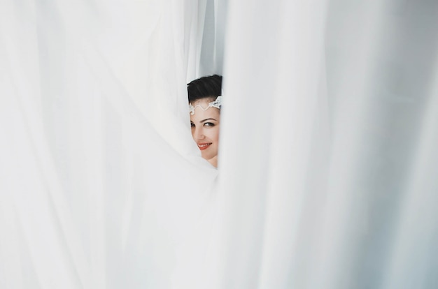 Woman peeking between curtains