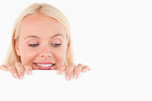 Photo woman peeking over a whiteboard