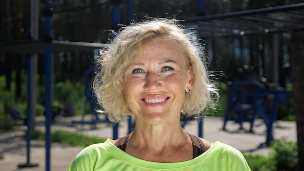 Woman pensioner with wrinkles looks straight closeup